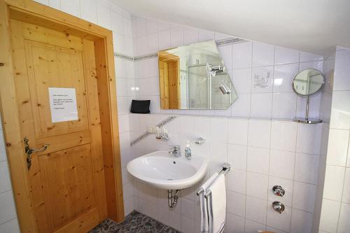 een badkamer met een wastafel en een spiegel bij Bauernhof Ertlhof in Sachrang