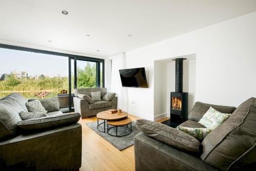 Una sala de estar con dos sofás y una chimenea. en Luxury lakeside property with spa access ML44, en Cirencester
