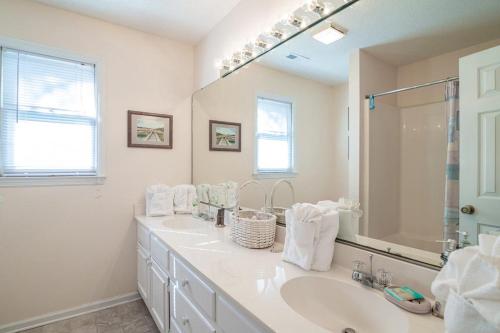 a bathroom with two sinks and a large mirror at A Some Place Special Minutes to Beach Sleeps 10 in Pawleys Island