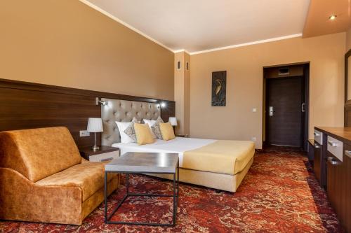 a hotel room with a bed and a chair at Business Hotel Plovdiv - Central Location in Plovdiv