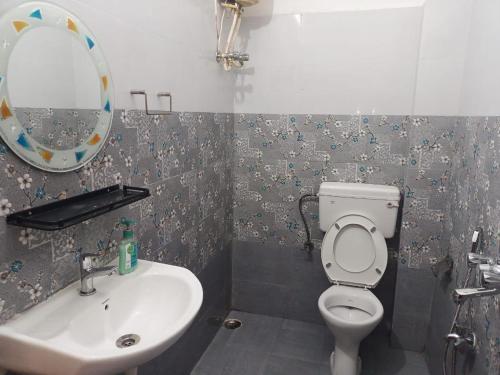 a bathroom with a sink and a toilet and a mirror at Urbban Castle in Port Blair