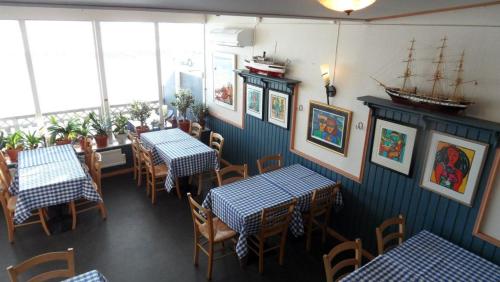 a restaurant with tables and chairs and a boat on the wall at Håknäs Vandrarhem in Järna