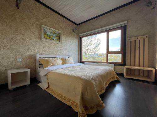a bedroom with a large bed and a window at Ladera Resort Qusar in Qusar