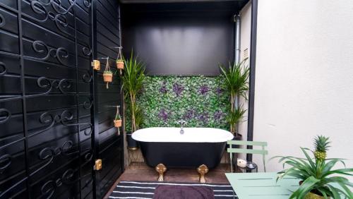 a bathroom with a bath tub and plants at Luxury Copacabana proche Orly et Paris avec baignoire extérieur in Draveil