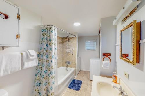 Baño blanco con bañera y lavamanos en Anchor Court Views en Lincoln City