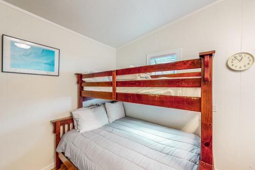 een slaapkamer met een stapelbed en een klok aan de muur bij Anchor Court Views in Lincoln City