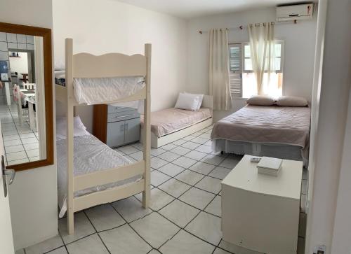 パリョサにあるCasa pé na areia Ponta do Papagaioの二段ベッド2台と鏡が備わる客室です。