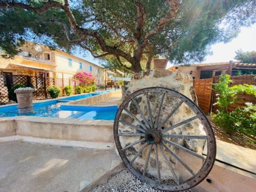 a statue of a wagon wheel in front of a house at Finca Sa Canova Agroturismo in Campos