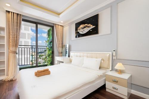 a white bedroom with a bed and a balcony at TeeUp Home - Infinity Pool Signature in Ho Chi Minh City