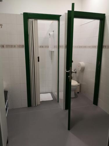 a bathroom with a toilet and an open door at Hostel de las Facultades in Santander
