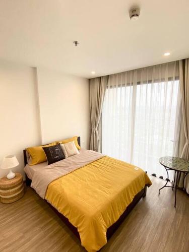 um quarto com uma cama grande e um cobertor amarelo em Stellar's Haven near High Tech Park with Stunning View and POOL em Gò Công