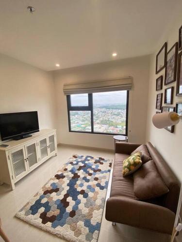 uma sala de estar com um sofá e uma grande janela em Stellar's Haven near High Tech Park with Stunning View and POOL em Gò Công