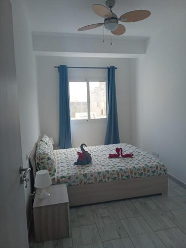 a bedroom with two slippers on a bed with a window at Casa Veronica Boavista in Sal Rei