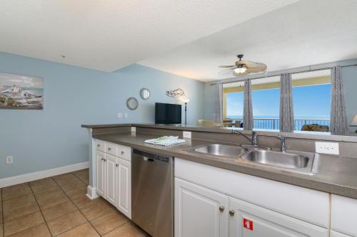 een keuken met een wastafel en een raam met uitzicht op de oceaan bij Majestic Beach Towers I 1105 in Panama City Beach