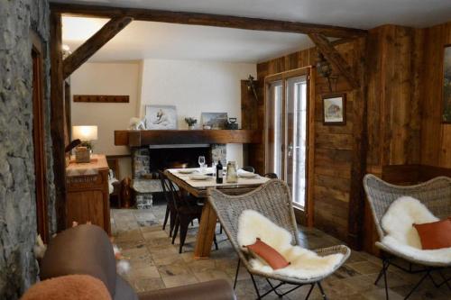 un salon avec une table et des chaises et une cheminée dans l'établissement Appartement typique de montagne, à Chamonix-Mont-Blanc