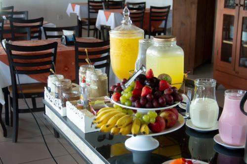 a table topped with two plates of fruit and drinks at Refúgio Escarpas do Lago in Capitólio