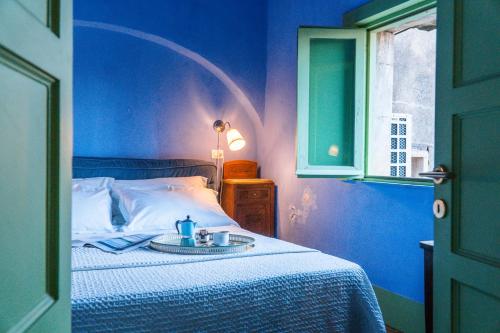 een blauwe slaapkamer met een bed met een dienblad erop bij Casa D'aria in Catania