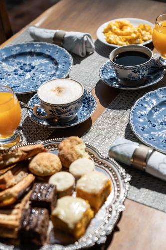 a table with plates of food and cups of coffee at Posada Manuel Lobo in Colonia del Sacramento