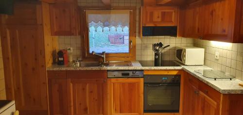 a kitchen with a sink and a microwave at Le Passage in Salvan