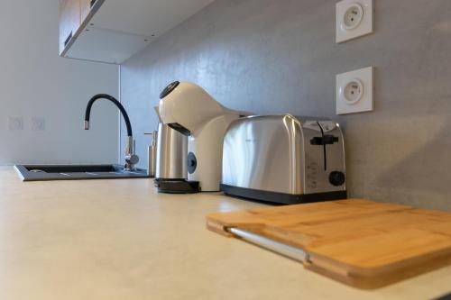 a kitchen counter with a toaster and a cutting board at La Cascade in Mâcon