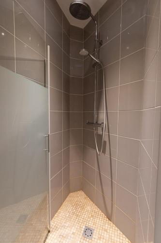 a shower with a glass door in a bathroom at La Cascade in Mâcon