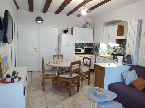 une cuisine et un salon avec une table et des chaises dans l'établissement Villa L'Orée du bois, à Le Mont-Dore