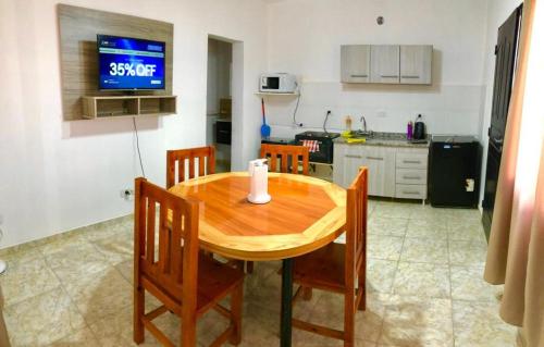 kuchnia z drewnianym stołem z krzesłami i telewizorem w obiekcie Apart PATRICIA I w mieście San Luis