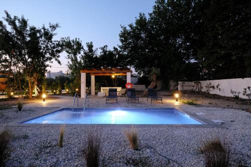 einen Pool im Garten mit Tisch und Stühlen in der Unterkunft Elia suites in Ialysos
