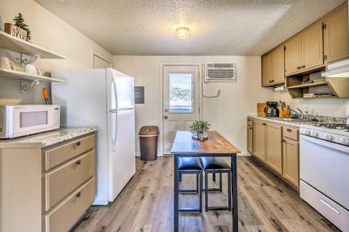 a kitchen with a table and a refrigerator at Ruidoso Downs Fritz Cabin with Covered Patio! in Ruidoso Downs