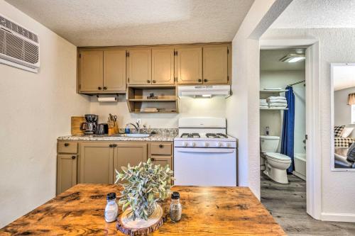 a kitchen with a wooden table and a white stove at Ruidoso Downs Fritz Cabin with Covered Patio! in Ruidoso Downs