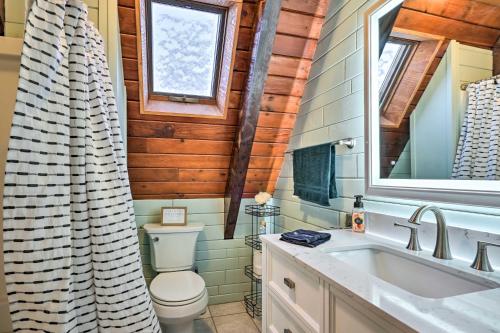 La salle de bains est pourvue de toilettes, d'un lavabo et d'une fenêtre. dans l'établissement Rustic LaFayette A-Frame Cabin with Game Room!, 