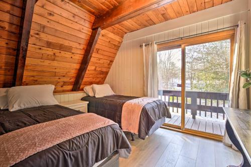 two beds in a room with a window at Rustic LaFayette A-Frame Cabin with Game Room! 