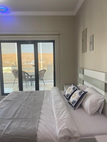 a bedroom with a bed with a view of a balcony at Home X4 in Al Wāşil