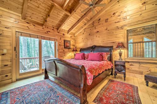 a bedroom with a bed in a log cabin at Walk to Golfing Grand Maggie Valley Cabin! in Maggie Valley