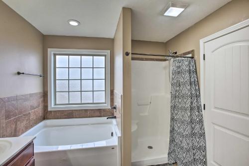La salle de bains est pourvue d'une baignoire et d'une fenêtre. dans l'établissement Clarksville Getaway Near Golfing and Breweries!, à Oak Grove