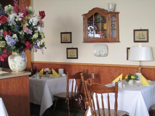 une salle à manger avec deux tables et un vase de fleurs dans l'établissement Motel Hamburg, à Hambourg