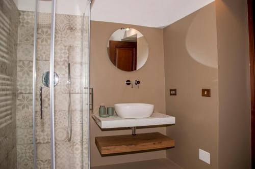 a bathroom with a sink and a shower at Pavì Trulli e Suites in Locorotondo