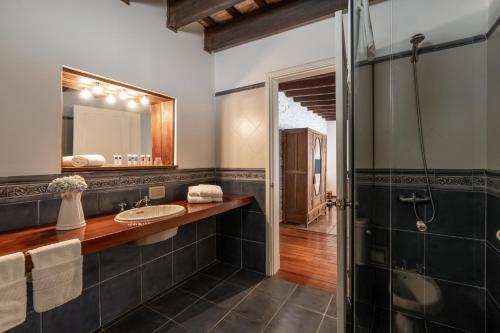 y baño con lavabo y ducha. en Posada Manuel Lobo, en Colonia del Sacramento