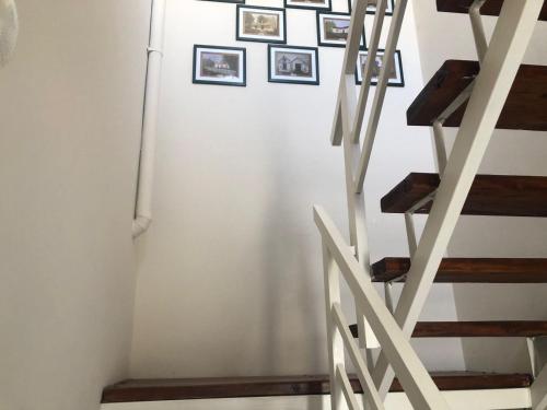 a white refrigerator next to a staircase with pictures on the wall at CALAFATE CENTER APARTS in El Calafate
