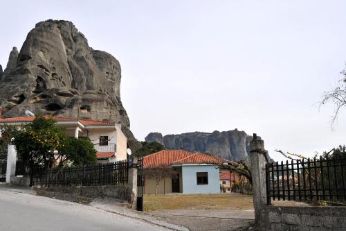 a house with a fence in front of a mountain at Ananta House in Kalabaka