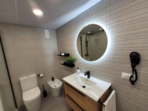 a bathroom with a toilet and a sink and a mirror at Apartamento Ejido Centro in El Ejido