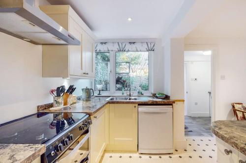 eine Küche mit gelben Schränken und einem Waschbecken in der Unterkunft Stunning one bedroom apartment in Honor Oak in London