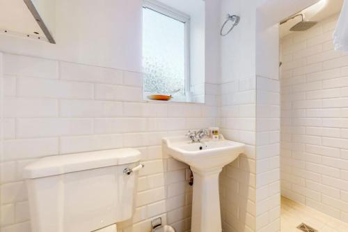 Baño blanco con lavabo y aseo en Stunning one bedroom apartment in Honor Oak en Londres