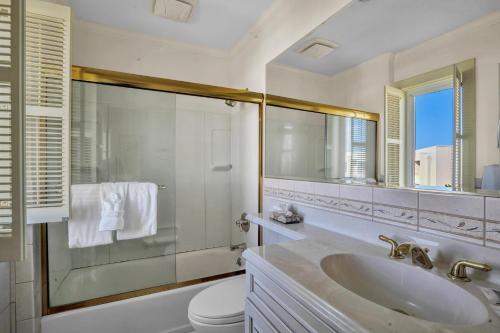 a bathroom with a sink and a toilet and a mirror at The Hermitage at Napeague in Amagansett