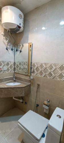 a bathroom with a toilet and a sink at راحة الوفود الفندقيه in Al Khansāk