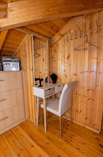 a table and a chair in a room with wooden walls at Villa Galateia in Dhafnés