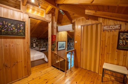 a bedroom with wooden walls and a bed in a room at Villa Galateia in Dhafnés