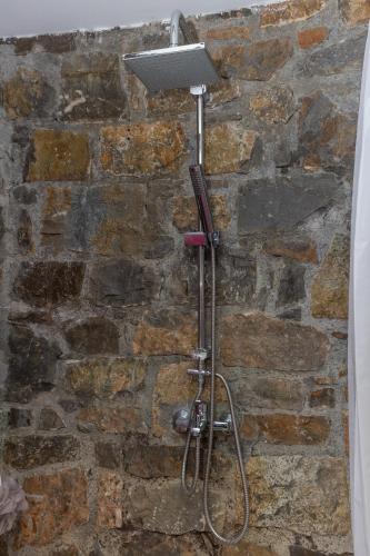 a shower head on a stone wall at Villa Galateia in Dhafnés