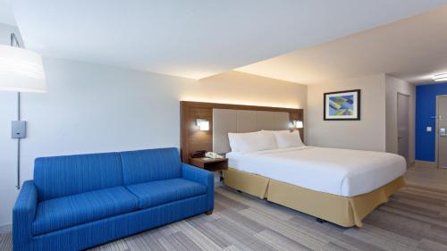 マイラ・メサにあるHoliday Inn Express Mira Mesa San Diego, an IHG Hotelのベッドルーム(ベッド1台、青いソファ付)