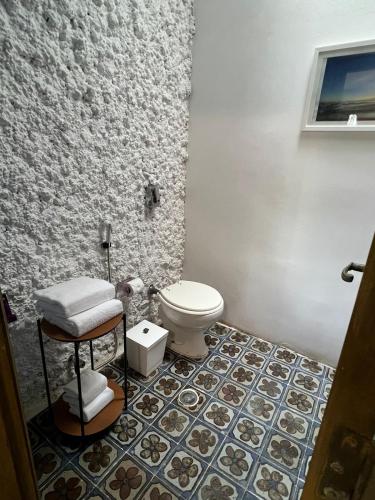 a bathroom with a toilet and a tile floor at Hotel Casa Paradiso Guarujá in Guarujá